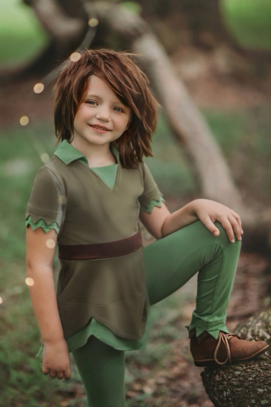 A young child is wearing an earthy green tunic with leaf green collar. The short sleeves have a double layer detail. The bottom hem is a handkerchief cut.