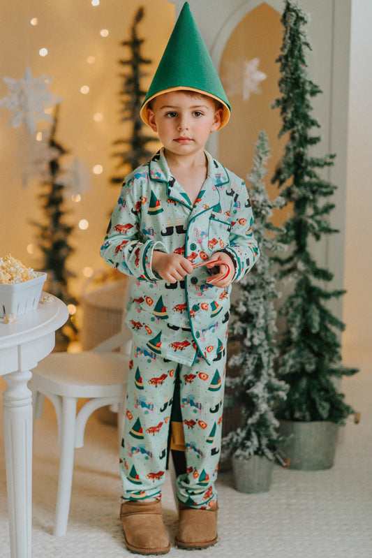 Child dressed in green Christmas pajamas with matching elf cone hat, standing in a winter-themed holiday setup
Boys festive holiday pajamas with playful Christmas print and felt elf hat, styled for family photos and Christmas morning
Toddler in Christmas sleepwear with reindeer and elf hat pattern, wearing slippers in cozy holiday backdrop with twinkle lights