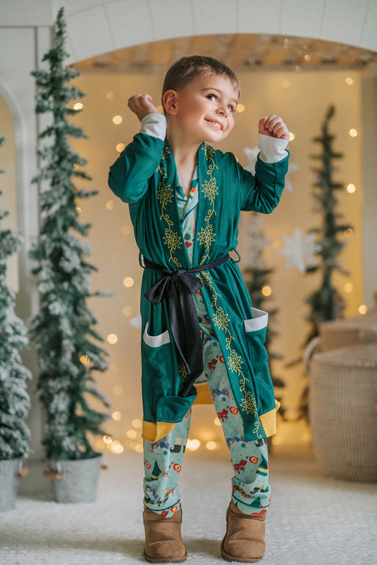 Child dressed in green Christmas pajamas with matching elf cone hat, standing in a winter-themed holiday setup
Boys festive holiday pajamas with playful Christmas print and felt elf hat, styled for family photos and Christmas morning
Toddler in Christmas sleepwear with reindeer and elf hat pattern, wearing slippers in cozy holiday backdrop with twinkle lights