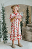 Vintage-style girls Christmas nightgown with red bows, holly print, ruffle trim, and satin bow, hanging on a carved white mirror
Classic holiday pajama dress for girls with red and green holly print, ruffle hem, and red satin bow at the neckline
Girls long sleeve Christmas nightgown with festive red bow and holly pattern, styled for holiday photos or heirloom gifting
Traditional girls holiday nightgown in white with red an