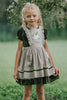 Heirloom-style green velvet holiday dress with linen pinafore and pumpkin embroidery, styled for autumn or fairytale dress-up