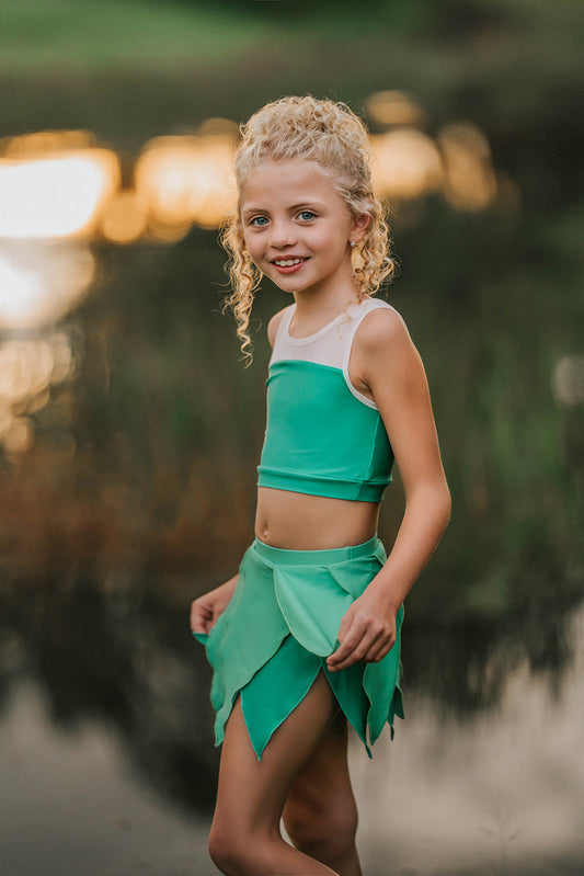 Girl wearing green fairy costume with leaf-style skirt and crop top, styled for dress-up or Tinkerbell-inspired photo shoot
Child in green leaf skirt and matching top posing outdoors, perfect fairy or nature-themed costume for girls
Little girl in Tinkerbell-inspired green outfit with layered leaf skirt and sleeveless top, styled for whimsical dress-up