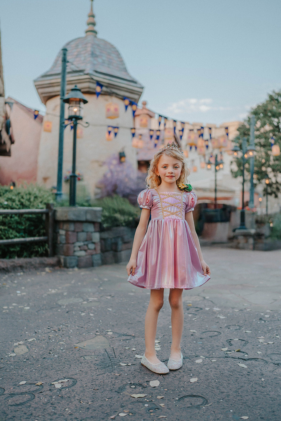 Metallic Rapunzel twirl dress in pastel pink and purple with shiny criss‑cross gold ribbon bodice and puff sleeves – boutique girls princess costume perfect for parties and photoshoots.