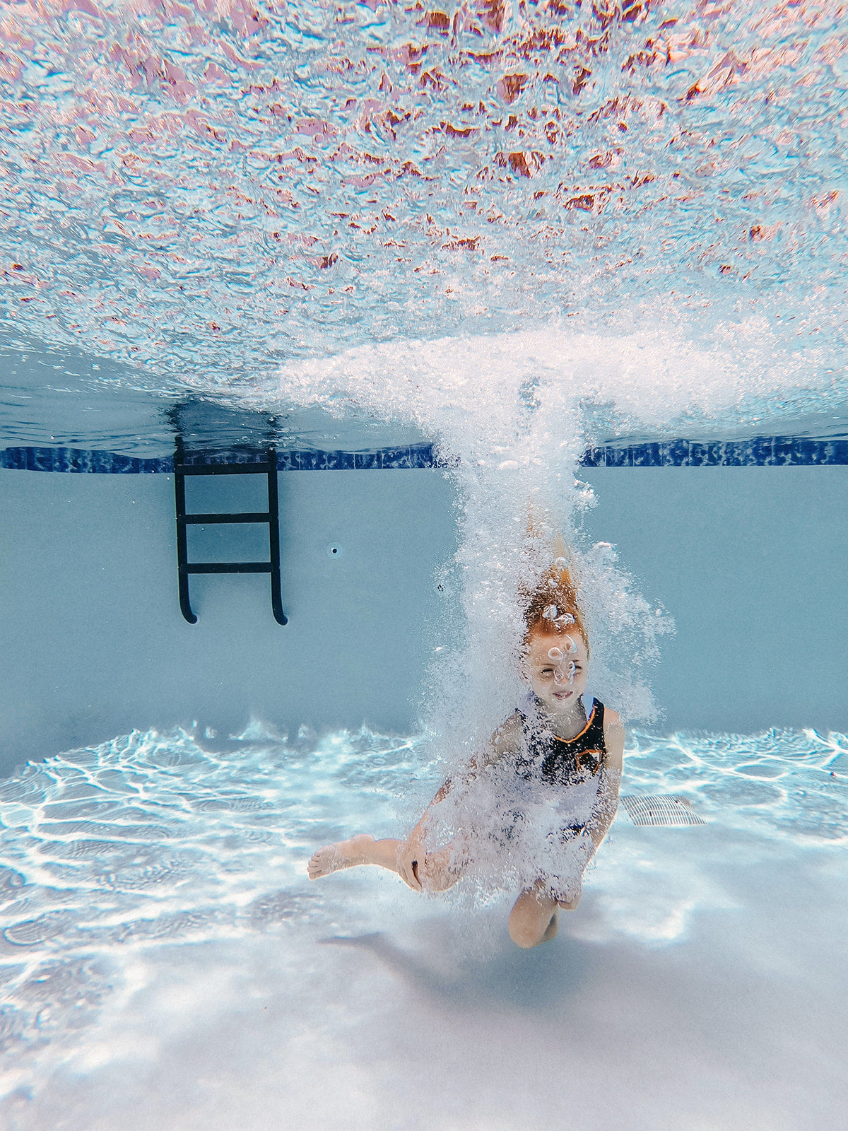 Child modeling magical girl-themed two-piece swim set with gold and red crest. Perfect for a wizard and hot day at hogwarts.