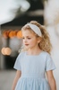 The Micro Beaded Floral Celebration Headband is white with small white white beads in various shapes. They are sewn in floral patterns and scattered to cover the headband. This hair accessory is designed for all day comfort.