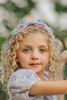 Our Rapunzel Headband is a lavender satin with multicolored flowers made out of different shaped sequins and beads. The flowers are teal, yellow, pink, purple and mint colored. This hair accessory is comfortable and designed for all day wear.