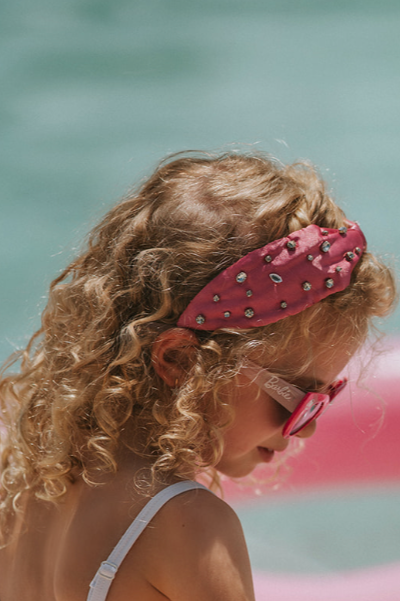 The Iconic Doll Sleeping Beauty Headband is pink satin with crystal rhinestones sewn all over. The headband is comfortable and designed for all day wear. This accessory is perfect for a princess or fashionista.