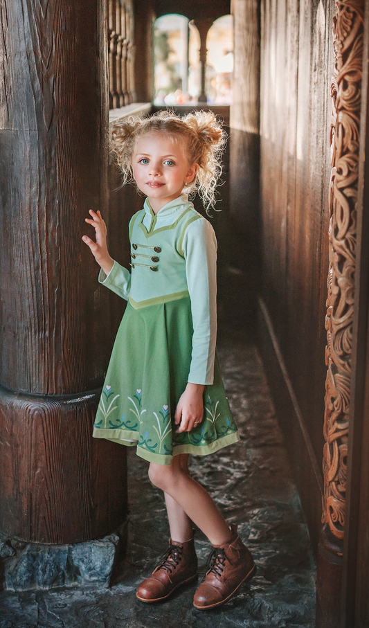 For the first time in forever....a long sleeve cotton twirl dress in spring greens. The bodice is adorned with 6 buttons and iridescent ribbon. There is a faux vest look and the skirt is a bright earthy green with floral pattern on the hem. Perfect for getting out of the castle.