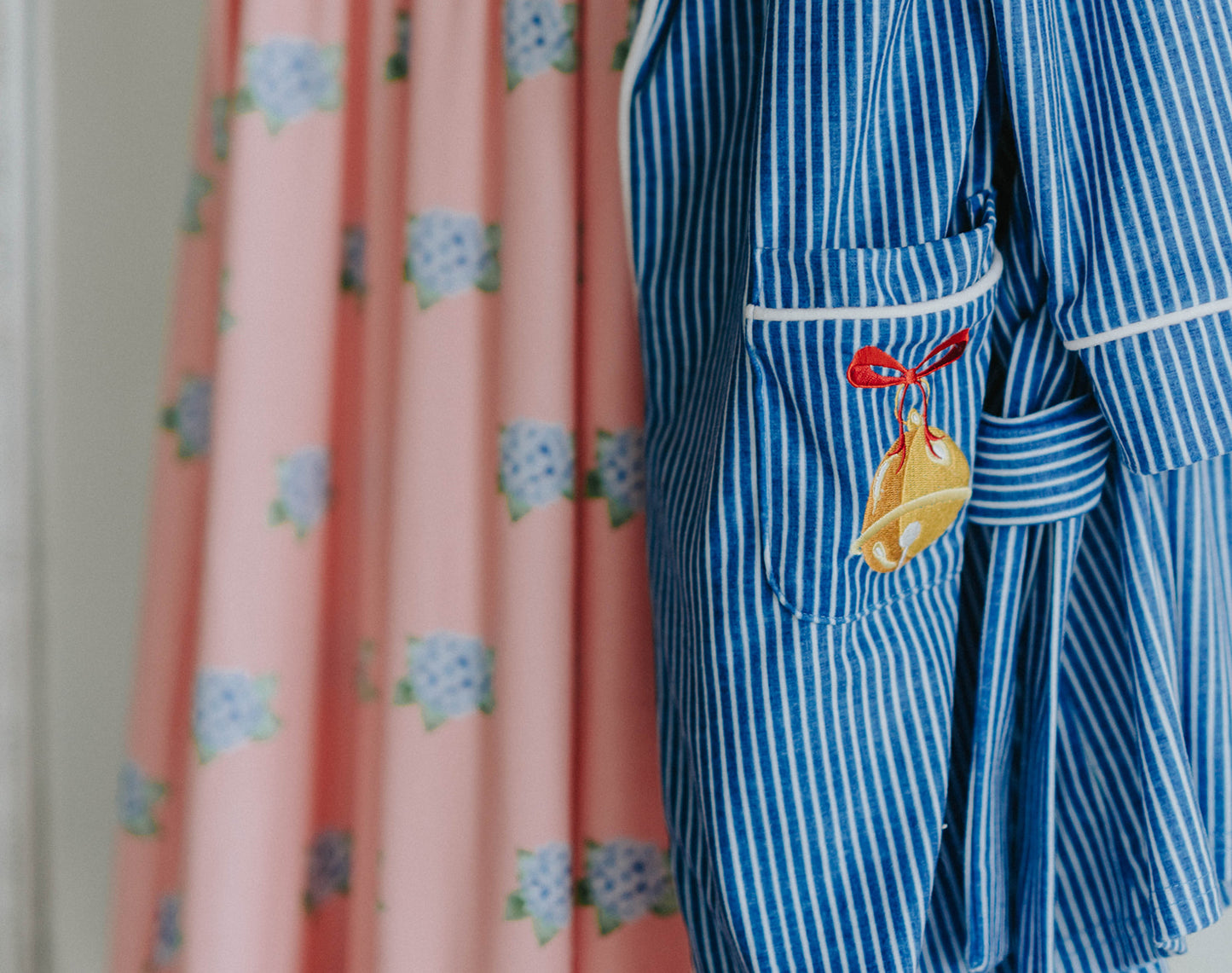 Close-up of child wearing blue striped Polar Express robe with gold bell embroidery on pocket and cozy Christmas pajamas underneath
Kids holiday robe inspired by Polar Express with white piping, gold bell patch, and tie waist, styled for Christmas morning
Blue and white striped Christmas robe with gold bell detail, worn by child with cozy holiday pajamas and slippers
Polar Express-themed unisex robe with gold bell embroidery and piping trim, perfect for kids’ Christmas sleepwear