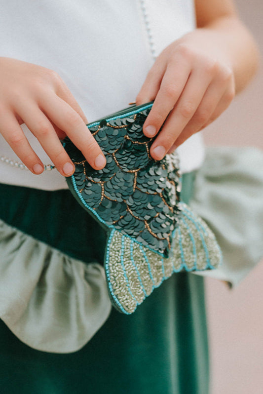 🧜♀️✨ Make Waves with Every Outfit!
This sparkly Mermaid Tail Beaded Purse is made for underwater daydreamers and land-loving mermaids alike! With shimmering green sequins, a glittery beaded fin, and a dainty crossbody chain, this purse adds a splash of magic to any outfit.
Perfect for birthdays, beach trips, pretend play, or dress-up days, this bag turns every moment into an ocean-inspired fairytale.
🌊 Product Highlights:
Shaped Like a Mermaid Tail – Features a scalloped sequin body and beautifully b