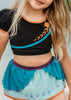 A young girl is wearing a 2 piece long sleeve rash guard swim set. The top is black with turquoise and goldenrod accents. The bottom has a turquoise ruffle over a mint teal skirt with goldenrod hem accent.
