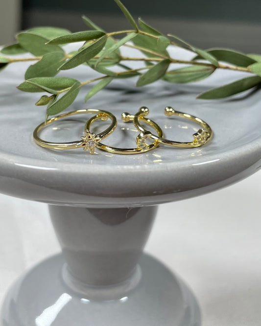 Three rings sold separately. Golden with starburst. The second is a crescent moon and adjustable. The last is a star and adjustable.