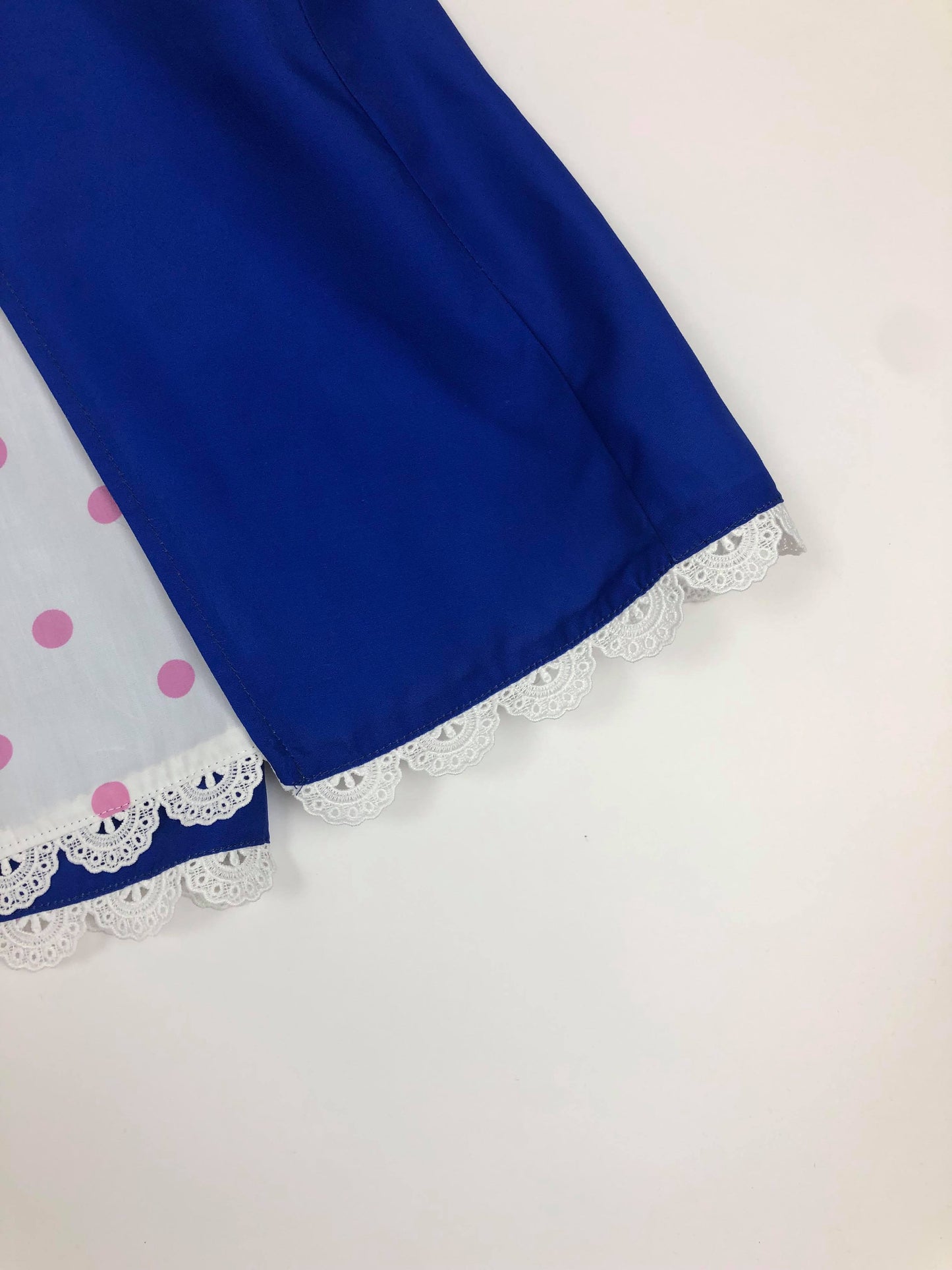 A light blue romper adorned with white lace trim, and leggings with ruffled ends. The flutter sleeves are eyelet lace.