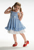 A young girl in a Dorothy pinafore Twirl dress from the Book Character Collection, showcasing a woven cotton gingham blue and white checkered pattern with delicate white lace trim.