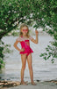 Girl wearing pink princess-inspired swimsuit with gold embroidery and ruffle off-shoulder detail, posing barefoot by the water

Girls royal-themed pink and gold one-piece swimsuit with peplum skirt, styled with ruffled straps and heart sunglasses

Princess bathing suit for girls in hot pink with gold lace trim and off-shoulder ruffles, perfect for summer dress-up swimwear