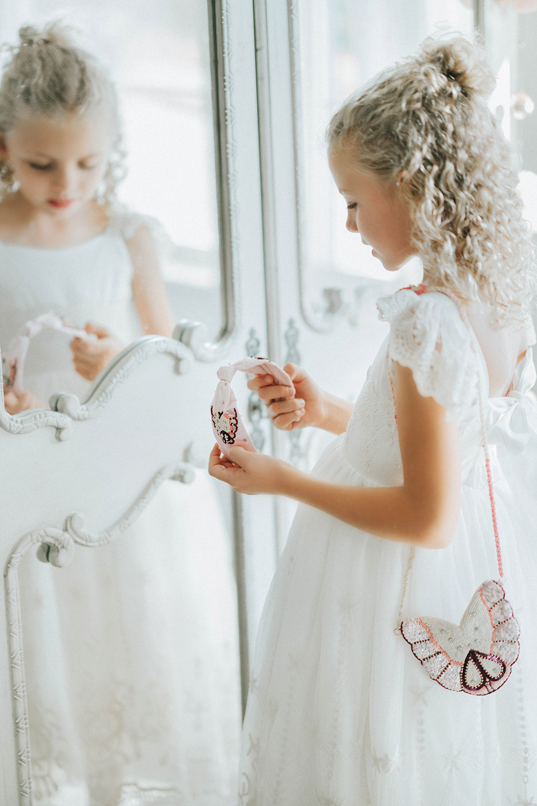 Girls’ butterfly-shaped beaded purse with sequin wings and pink strap, styled with an elegant white dress

Delicate butterfly crossbody purse with beaded wings and sparkle detail, perfect for dress-up or special occasions

Iridescent butterfly beaded bag hanging from a girl's shoulder, styled with embroidered white gown

Whimsical sequin butterfly purse for girls with pink and pearl beading, ideal for weddings or birthday dress-up