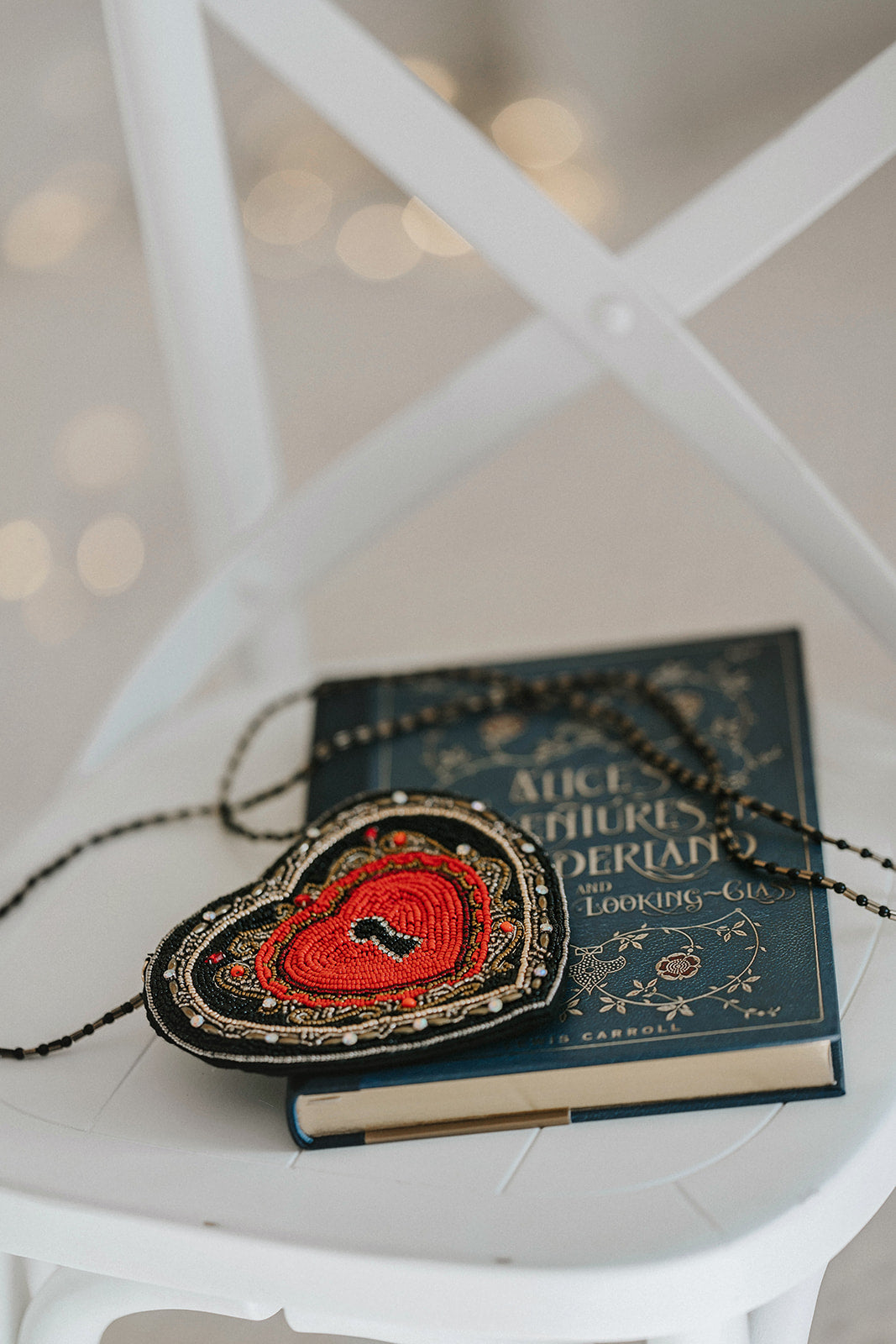 Hand-beaded heart crossbody purse with red center and black trim, styled for gothic princess look with white bubble dress and navy tartan scarf, ideal for Valentine’s Day.

Girls fantasy handbag with keyhole embroidery and red beaded heart design, perfect for magical dress-up, boutique accessories, or romantic themed events.

Unique hand-beaded Valentine’s purse shaped like a heart with black and red seed beads, worn with a winter dress for holiday photo sessions or princess accessories.