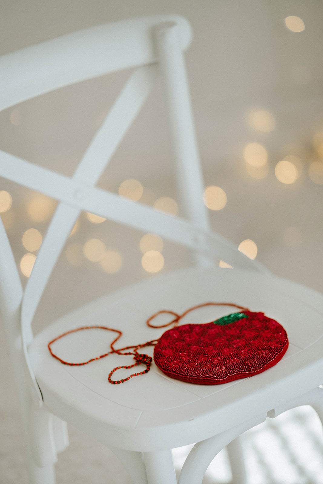Red beaded apple purse with crossbody strap displayed on white chair, perfect for teacher appreciation, fall outfit accessory, or whimsical classroom gift for school season.

Close-up of fruit-shaped beaded handbag in apple design, styled for girls and teachers, makes the perfect fall fashion accessory or back to school photo prop for autumn.

Whimsical red apple purse handcrafted with seed beads, green leaf detail, and long beaded strap, ideal for gifting teachers, students, or celebrating fall in playful 