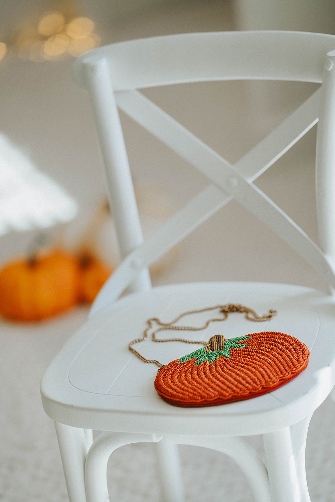 Beaded pumpkin-shaped purse with orange seed beads, green leaf detail, and gold chain strap, styled on a white chair with mini pumpkins for fall or Halloween accessories.

Hand-beaded pumpkin purse with green leaves and gold chain, perfect autumn handbag for Halloween outfits, Thanksgiving events, or cozy fall accessories.

Fall-themed pumpkin crossbody bag with beaded design and gold strap, styled with mini pumpkins on a white chair, ideal for spooky season or Thanksgiving gifting.