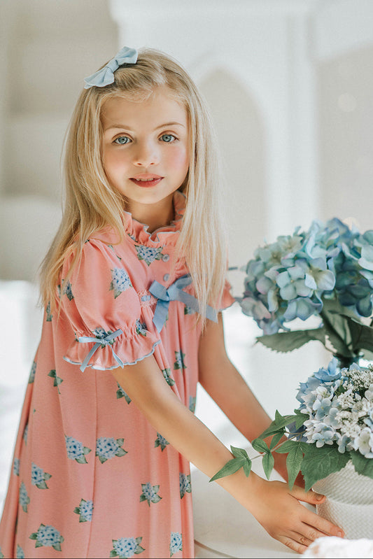 Vintage-inspired pink girls nightgown with blue floral print, ruffled hem, and puff sleeves, perfect for lounging