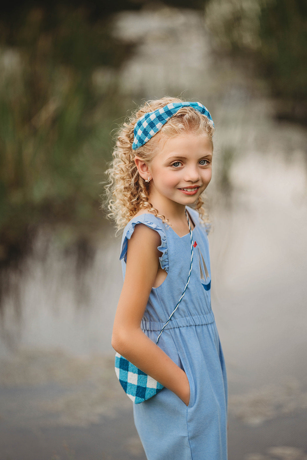 Close-up of child in buffalo check headband and blue outfit, ideal for spring photo shoots or vintage-inspired kids fashion

Blue and white plaid beaded headband on young girl with curly blonde hair, styled outdoors for summer dress-up or gifting

Toddler to tween wearing blue gingham headband, styled with coordinating romper and heart purse for picnic-ready outfit

Hand-beaded gingham headband worn by girl outdoors, featuring classic blue buffalo plaid for timeless cottagecore look
