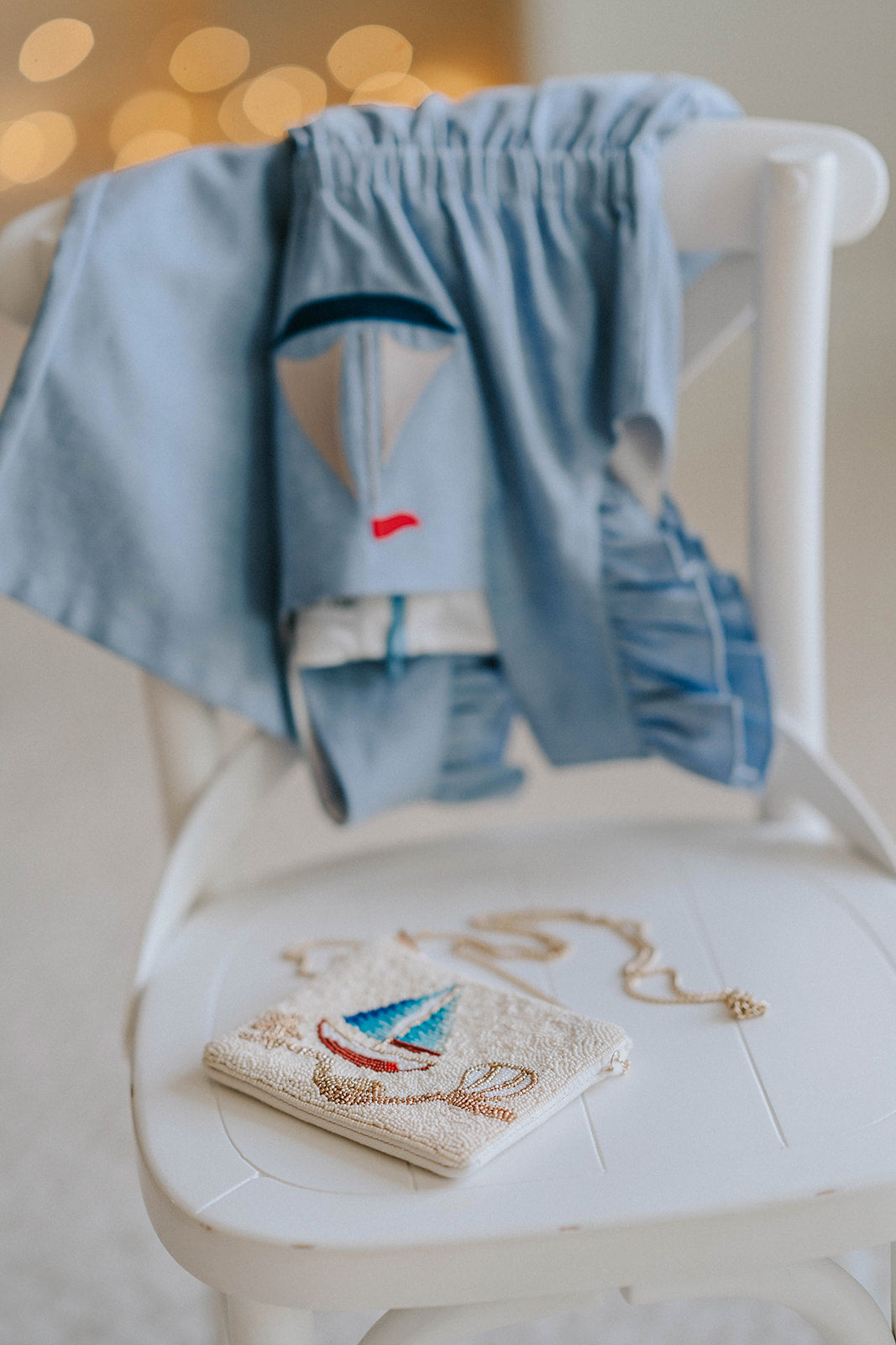 Beaded sailboat purse with red, blue, and gold details resting on white chair, styled with blue coastal outfit for girls

Close-up of nautical beaded crossbody bag featuring a colorful sailboat design, perfect for beach trips or summer gifting