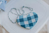 Close-up of heart-shaped beaded crossbody bag in blue buffalo plaid, styled for spring, Valentine’s Day, or dress-up

Blue gingham heart purse made with delicate beads and braided strap, ideal for toddler gift or cottagecore accessory

Beaded blue and white heart-shaped purse with crossbody strap, styled as a girls fashion or holiday photo prop

Girls’ gingham beaded purse in heart shape, featuring blue and ivory plaid design with braided handle for toddler or child