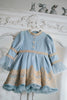 Victorian-inspired blue girls dress with gold embroidery, puff sleeves, and pearl buttons, perfect for birthdays or special occasions

Elegant heirloom girls dress in dusty blue with gold lace trim and tulle layers, hanging on ornate vintage-style mirror

Long sleeve blue and gold embroidered holiday dress for girls, featuring pearl buttons and layered tulle hem