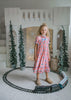 Long pink holiday nightgown with double ruffle trim and blue satin bows, ideal for Christmas Eve or heirloom sleepwear

Cozy pink floral girls pajama dress with puff sleeves and cascading ruffles, styled for bedtime or holiday memories

Charming pink nightgown with classic floral print and bows, styled with slippers and a holiday tree for seasonal photos