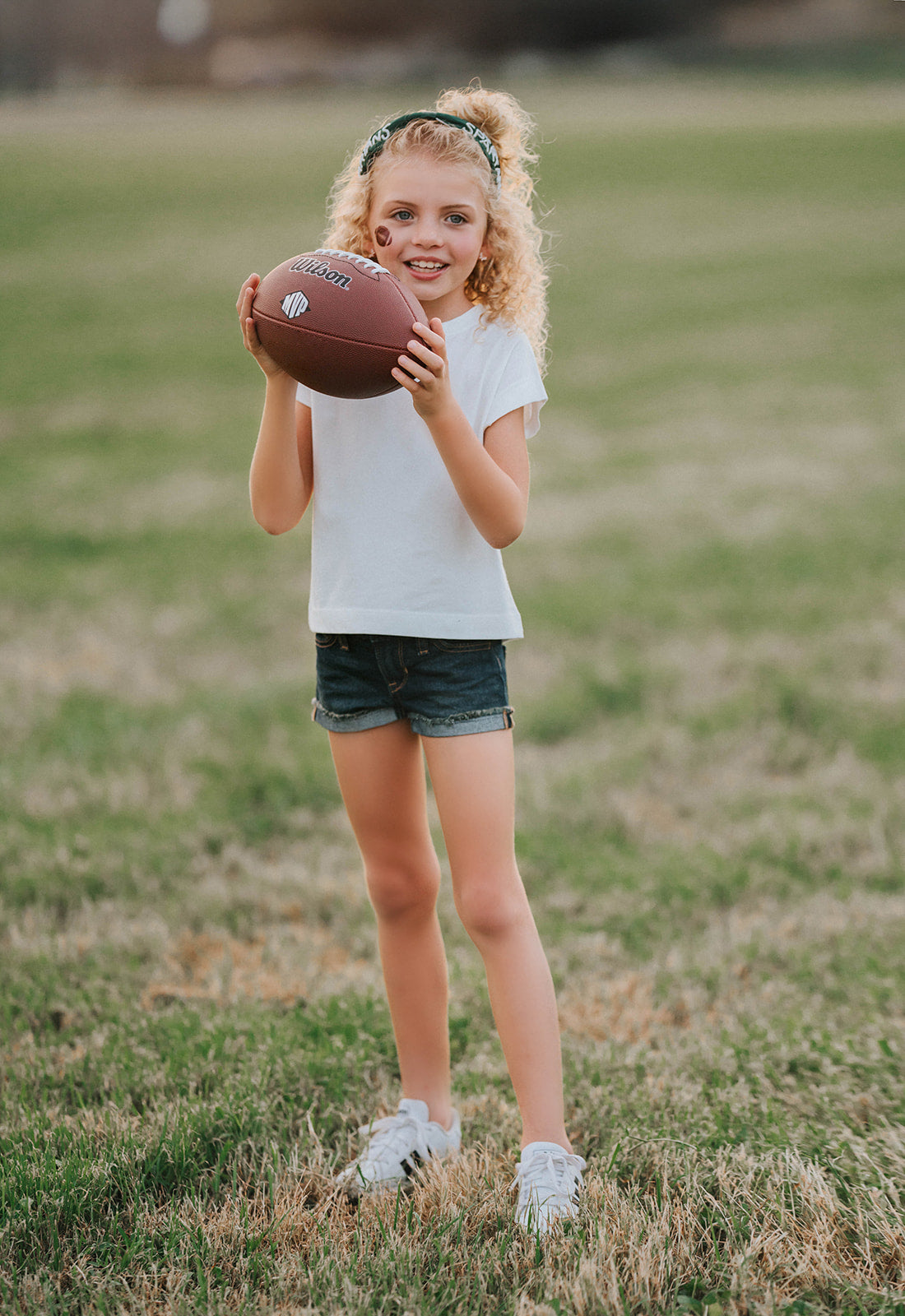 Girl wearing green “Go Spartans” headband holding a football on a grassy field at sunset, dressed in white tee and denim shorts

Child in team spirit outfit with green “Go Spartans” headband and football, perfect for game day or school pep rally

Little girl showing Spartan pride with beaded green headband and football, styled for fall sports or tailgate season

Girls football fan look with sparkly “Go Spartans” headband and casual outfit, standing in a field at golden hour