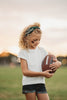 Girl wearing green “Go Spartans” headband holding a football on a grassy field at sunset, dressed in white tee and denim shorts

Child in team spirit outfit with green “Go Spartans” headband and football, perfect for game day or school pep rally

Little girl showing Spartan pride with beaded green headband and football, styled for fall sports or tailgate season

Girls football fan look with sparkly “Go Spartans” headband and casual outfit, standing in a field at golden hour