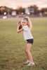 Girl wearing blue “Go Lions” headband holding football on a field at sunset, dressed in white tee and denim shorts

Child wearing sparkly blue team spirit headband that says “Go Lions,” styled with football face sticker and sporty outfit

Little girl showing team pride in “Go Lions” beaded headband while holding football during golden hour on the field

Girls football game day outfit with blue “Go Lions” headband and pigskin, perfect for team spirit wear or cheerleaders