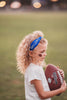 Girl wearing blue “Go Lions” headband holding football on a field at sunset, dressed in white tee and denim shorts

Child wearing sparkly blue team spirit headband that says “Go Lions,” styled with football face sticker and sporty outfit

Little girl showing team pride in “Go Lions” beaded headband while holding football during golden hour on the field

Girls football game day outfit with blue “Go Lions” headband and pigskin, perfect for team spirit wear or cheerleaders