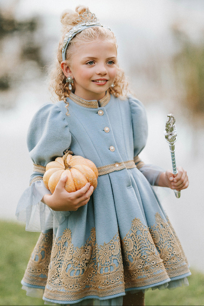 Victorian-inspired blue girls dress with gold embroidery, puff sleeves, and pearl buttons, perfect for birthdays or special occasions

Elegant heirloom girls dress in dusty blue with gold lace trim and tulle layers, hanging on ornate vintage-style mirror

Long sleeve blue and gold embroidered holiday dress for girls, featuring pearl buttons and layered tulle hem