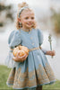Victorian-inspired blue girls dress with gold embroidery, puff sleeves, and pearl buttons, perfect for birthdays or special occasions

Elegant heirloom girls dress in dusty blue with gold lace trim and tulle layers, hanging on ornate vintage-style mirror

Long sleeve blue and gold embroidered holiday dress for girls, featuring pearl buttons and layered tulle hem