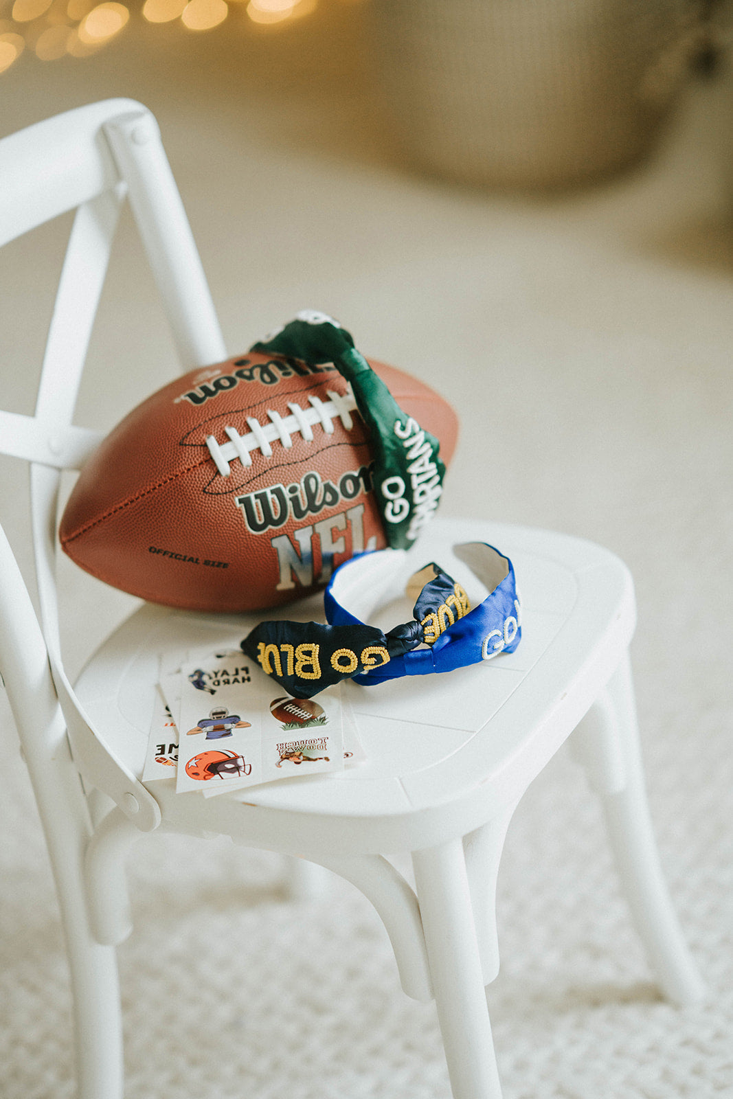 Girl wearing black “Go Blue” headband holding football on grassy field, dressed in white tee and denim shorts for game day

Child showing school spirit in sparkly “Go Blue” headband and football face sticker, styled for sports team support

Little girl wearing team pride headband that says “Go Blue” while smiling and holding a Wilson football outdoors

Blonde girl in football fan outfit with “Go Blue” headband and face paint, standing on a green field during sunset