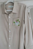 Boys beige button-up shirt with embroidered white pumpkin on chest pocket, hanging on vintage carved mirror for fall or Thanksgiving

Neutral boys fall shirt with embroidered pumpkin on pocket, styled for autumn photos, Thanksgiving, or sibling matching sets

Classic boys button-down shirt in light tan with embroidered blue pumpkin, perfect for harvest season or family portraits

Fall button-up shirt for toddlers and boys with embroidered pumpkin pocket detail, styled for Thanksgiving and heirloom outfits


