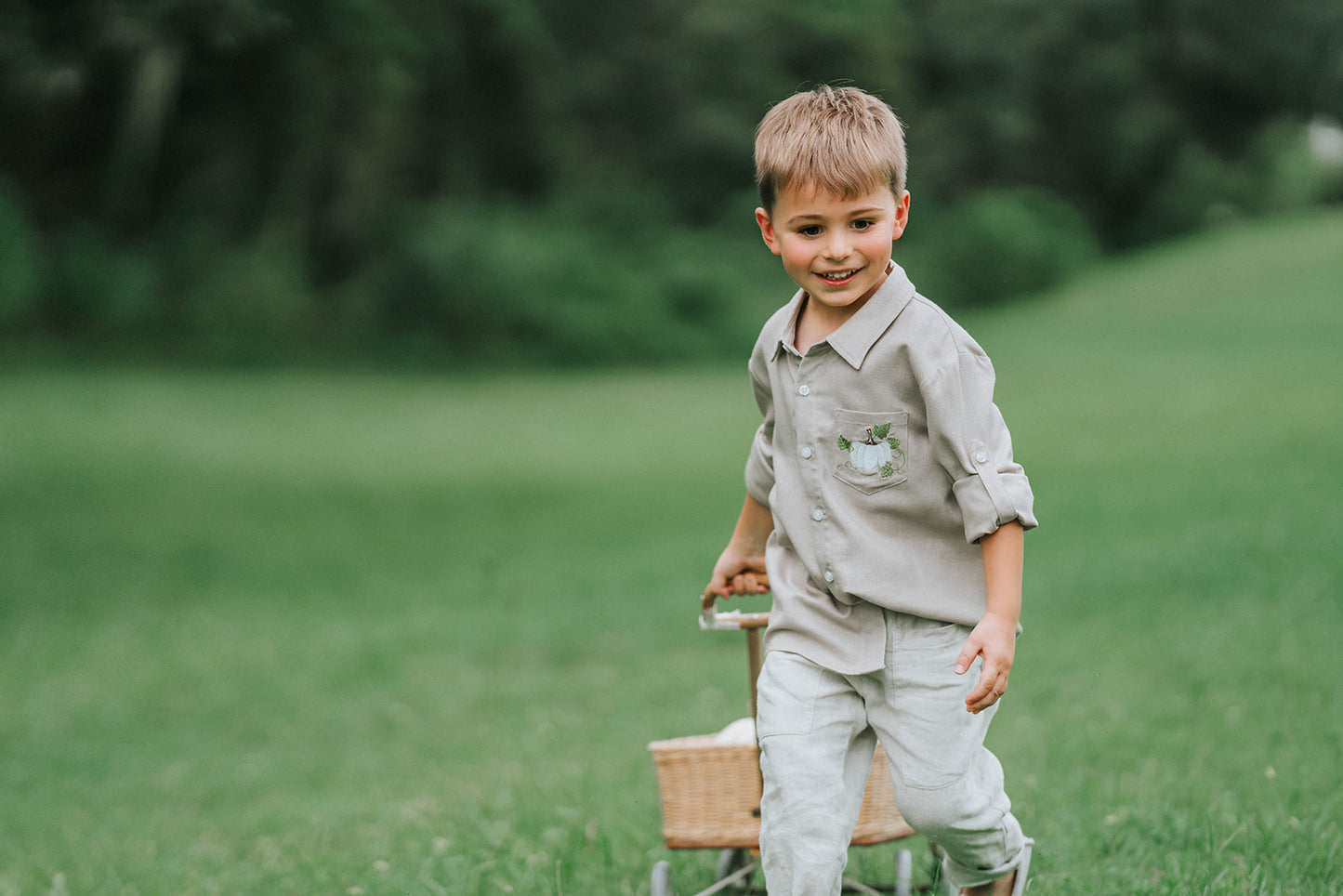 Boys beige button-up shirt with embroidered white pumpkin on chest pocket, hanging on vintage carved mirror for fall or Thanksgiving

Neutral boys fall shirt with embroidered pumpkin on pocket, styled for autumn photos, Thanksgiving, or sibling matching sets

Classic boys button-down shirt in light tan with embroidered blue pumpkin, perfect for harvest season or family portraits

Fall button-up shirt for toddlers and boys with embroidered pumpkin pocket detail, styled for Thanksgiving and heirloom outfits

