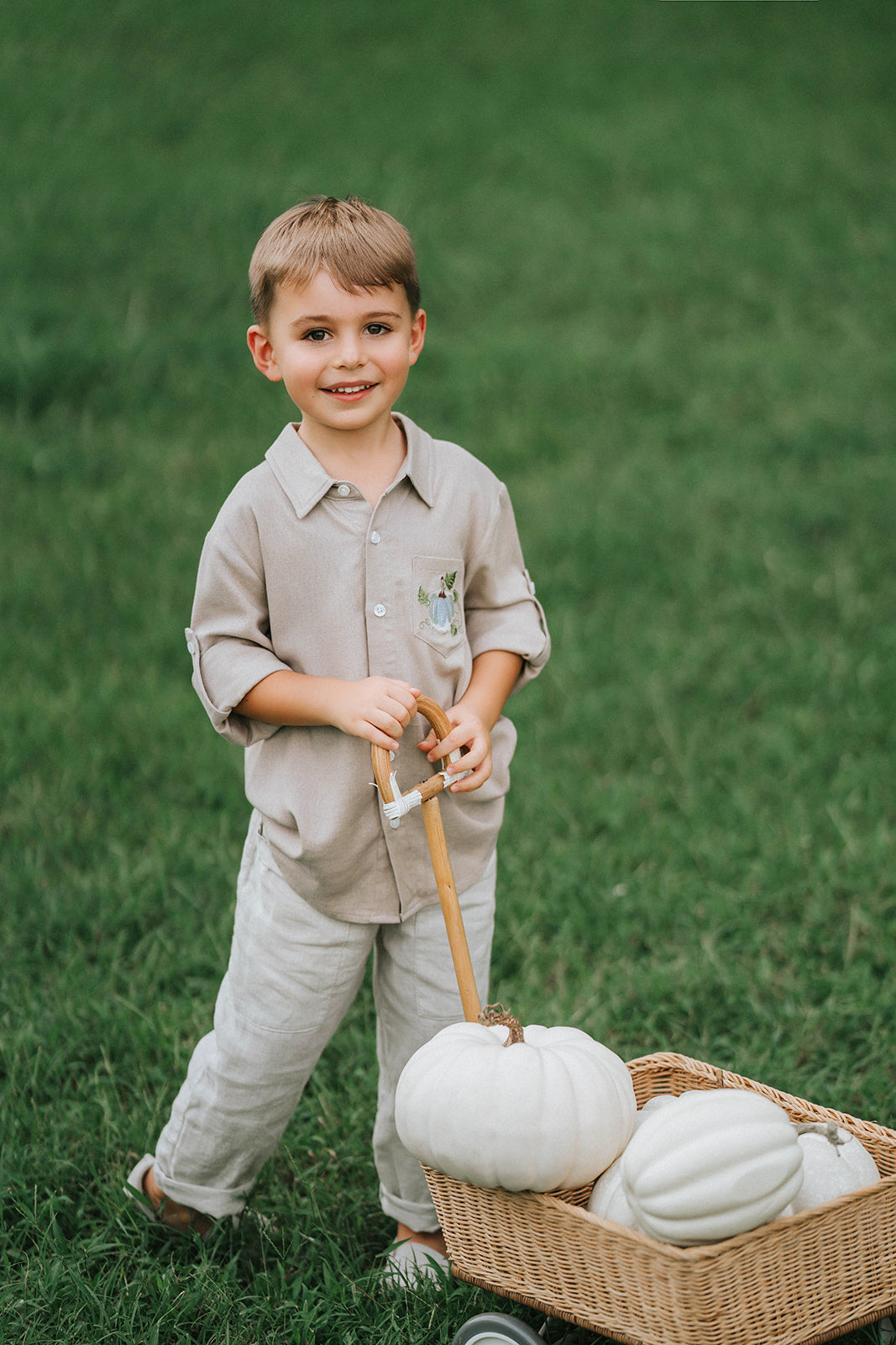 Boys beige button-up shirt with embroidered white pumpkin on chest pocket, hanging on vintage carved mirror for fall or Thanksgiving

Neutral boys fall shirt with embroidered pumpkin on pocket, styled for autumn photos, Thanksgiving, or sibling matching sets

Classic boys button-down shirt in light tan with embroidered blue pumpkin, perfect for harvest season or family portraits

Fall button-up shirt for toddlers and boys with embroidered pumpkin pocket detail, styled for Thanksgiving and heirloom outfits


