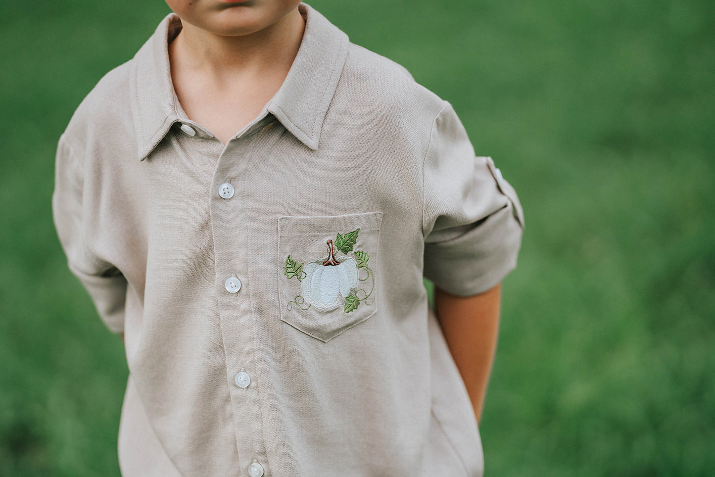 Boys beige button-up shirt with embroidered white pumpkin on chest pocket, hanging on vintage carved mirror for fall or Thanksgiving

Neutral boys fall shirt with embroidered pumpkin on pocket, styled for autumn photos, Thanksgiving, or sibling matching sets

Classic boys button-down shirt in light tan with embroidered blue pumpkin, perfect for harvest season or family portraits

Fall button-up shirt for toddlers and boys with embroidered pumpkin pocket detail, styled for Thanksgiving and heirloom outfits


