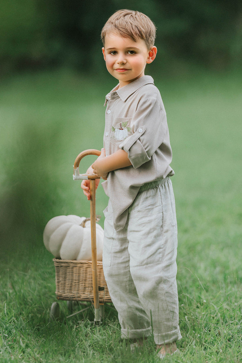 Boys beige button-up shirt with embroidered white pumpkin on chest pocket, hanging on vintage carved mirror for fall or Thanksgiving

Neutral boys fall shirt with embroidered pumpkin on pocket, styled for autumn photos, Thanksgiving, or sibling matching sets

Classic boys button-down shirt in light tan with embroidered blue pumpkin, perfect for harvest season or family portraits

Fall button-up shirt for toddlers and boys with embroidered pumpkin pocket detail, styled for Thanksgiving and heirloom outfits

