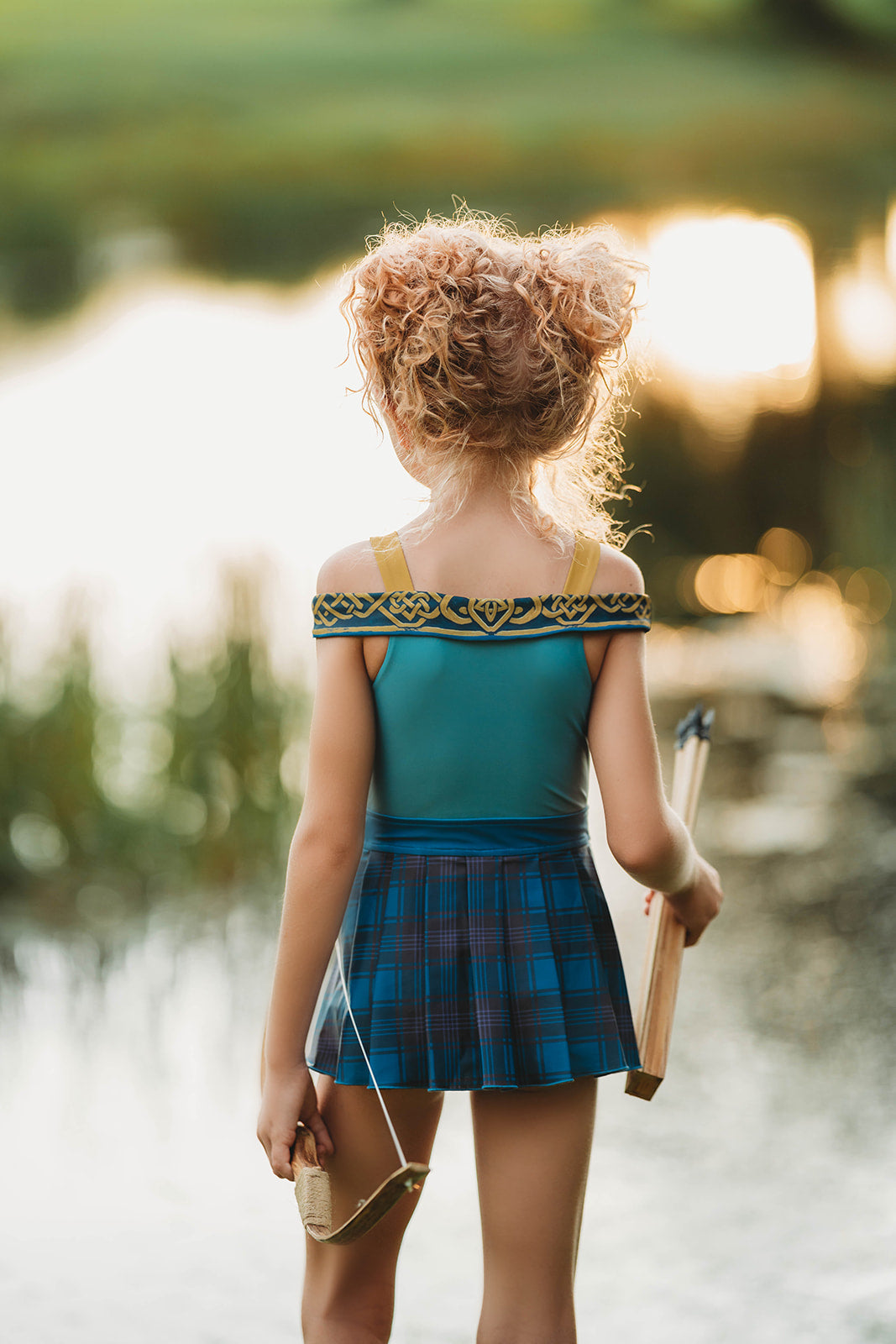 Scottish archer one-piece bathing suit with off-shoulder straps and golden knot trim, styled for adventurous girls

Tartan princess swimsuit with corset-style top and pleated sides, designed for play, pool, and pretend royalty

Celtic warrior girls swimsuit with gold embroidery and blue plaid accents, inspired by fairytales and Highland legends