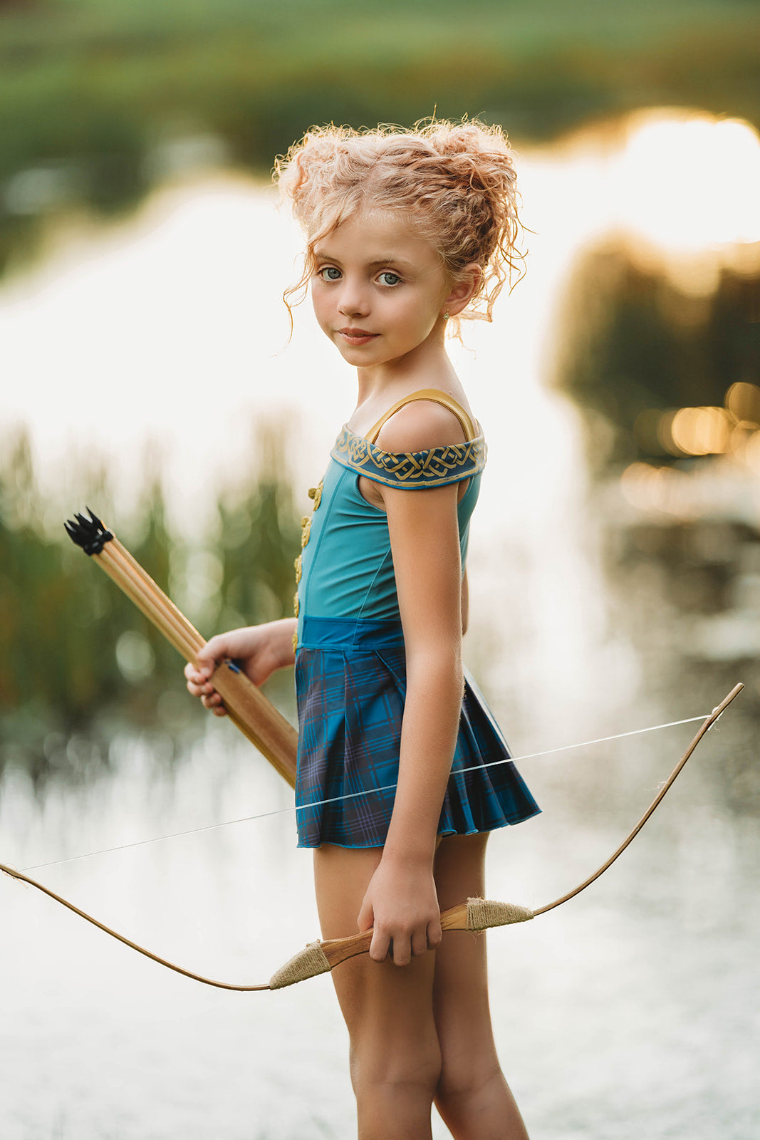 Scottish archer one-piece bathing suit with off-shoulder straps and golden knot trim, styled for adventurous girls

Tartan princess swimsuit with corset-style top and pleated sides, designed for play, pool, and pretend royalty

Celtic warrior girls swimsuit with gold embroidery and blue plaid accents, inspired by fairytales and Highland legends