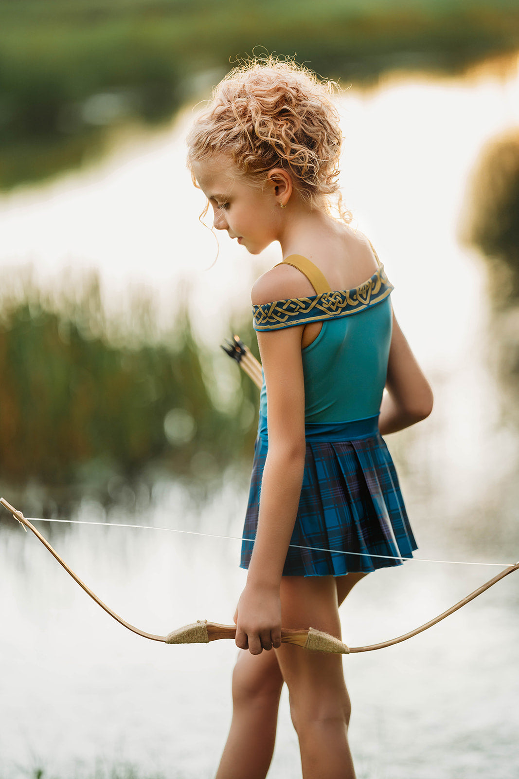 Scottish archer one-piece bathing suit with off-shoulder straps and golden knot trim, styled for adventurous girls

Tartan princess swimsuit with corset-style top and pleated sides, designed for play, pool, and pretend royalty

Celtic warrior girls swimsuit with gold embroidery and blue plaid accents, inspired by fairytales and Highland legends