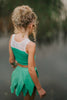 Child in green leaf skirt and matching top posing outdoors, perfect fairy or nature-themed costume for girls