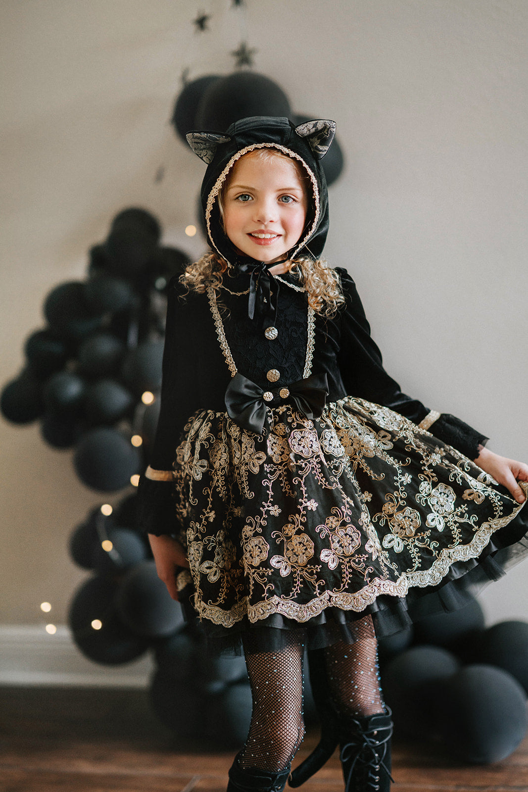 Girl wearing black velvet cat costume dress with gold embroidery, hooded ears, and satin bow, styled for Halloween or dress-up play

Elegant girls Halloween cat dress with hooded velvet top, gold lace trim, and full embroidered skirt, styled for spooky season

Gothic black and gold cat costume for girls with velvet hood, embroidered skirt, and satin bow, perfect for Halloween photoshoots

Child in hooded black cat dress with gold embroidery and velvet bodice, styled for Victorian Halloween or fairytale play