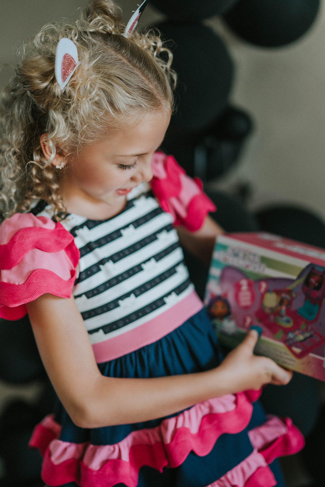 Girl wearing Gabby’s Dollhouse–inspired cat dress with pink and navy ruffles, striped kitty print bodice, and glitter cat ears

Girls ruffle party dress with black and white cat print top, pink waistband, and layered pink and navy skirt, styled for birthday

Gabby’s Dollhouse fan outfit featuring striped cat face bodice, double flutter sleeves, and tiered ruffle skirt for toddlers or girls

Child wearing a pink and navy cat-themed dress with kitty ears headband, perfect for dress-up, play, or themed birthda