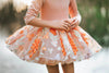 Boutique kids costume dress with matching floral cape and pumpkin tones – fairy-inspired twirl dress for fall celebrations