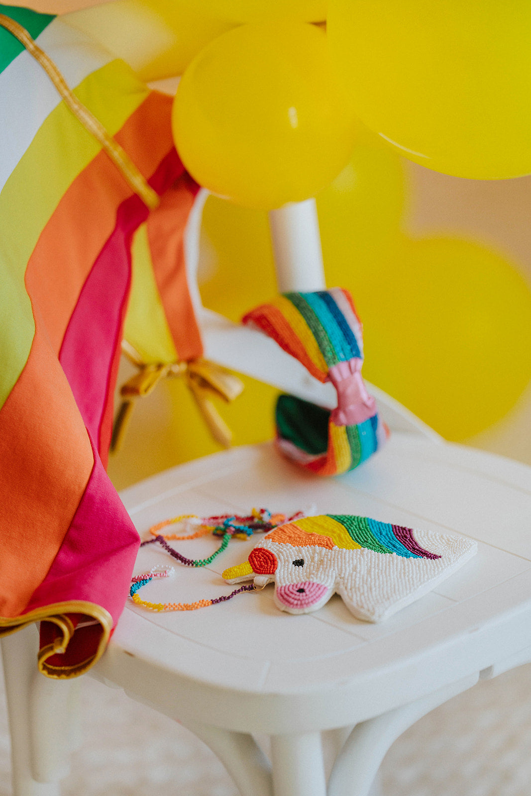 Hand-beaded kids unicorn crossbody purse in rainbow colors with matching rainbow accessories on white background