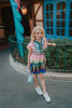 A vibrant metallic gown with colors of the rainbow. Pink flutter sleeves, tiered skirt perfect for twirling and a belted sash for that extra pizazz. 